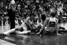 St. Cloud State University basketball player Dan Hagen and others pursue the basketball on the floor during a game against St. John's University