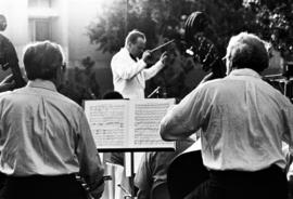 A man conducts an orchestra, Lemonade Concert and Art Fair, St. Cloud State University