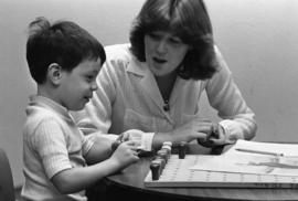 A woman works with a child, Speech Pathology, St. Cloud State University