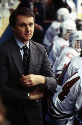 Herb Brooks coaches a hockey game behind the bench, St. Cloud State University