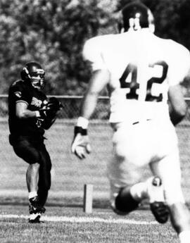 Mike McKinney catches a football during a football game, St. Cloud State University