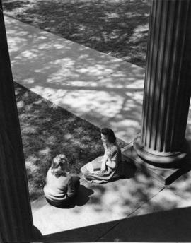 Two students sit at the front entrance of Old Main Building (1874), St. Cloud State University