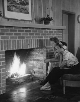 Two women enjoy the fireplace, Brainard Hall (1947), St. Cloud State University