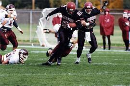 Mike McKinney runs with a football during a football game, St. Cloud State University