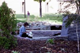 Woman sits in the World Commons Garden, St. Cloud State University