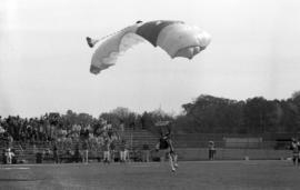 A man parachutes on the field before the homecoming football game