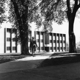 Student walks nearby the School of Business (1969) building, St. Cloud State University