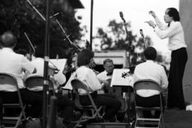 A man conducts an orchestra, Lemonade Concert and Art Fair, St. Cloud State University