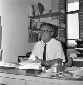 Ed Colletti sits at a desk, St. Cloud State University