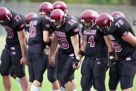 St. Cloud State football player Ramon Nunez (#74) and other men stand together in a row against the University of Minnesota - Duluth