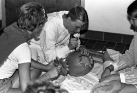 Woman carves a pumpkin at the Project Shore Halloween party, St. Cloud State University