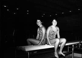 Michelle and Marlene Carlson sit together on a diving board, St. Cloud State University