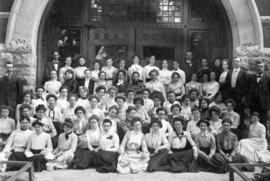 Men and women gather together in front of a building's door, St. Cloud State University