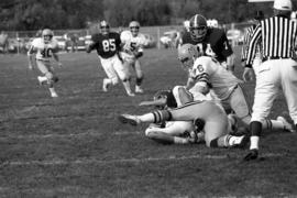 Football players tackle a St. Cloud State football player in a football game against the University of Minnesota-Morris