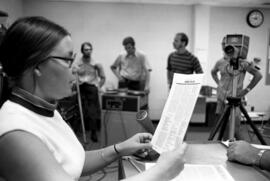 Woman reads from a document at a Mass Communications workshop, St. Cloud State University