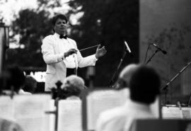 A man conducts an orchestra, Lemonade Concert and Art Fair, St. Cloud State University