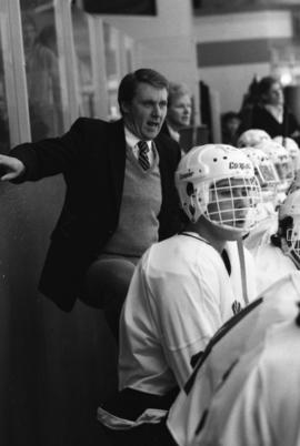 Herb Brooks stands behind the hockey bench, St. Cloud State University