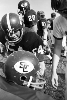 St. Cloud State University football player Tom O'Neel (#64) talks to a teammate during a game against St. John's University